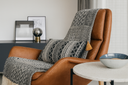 Brown armchair with a cushion and a throw in black and white